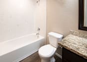 Thumbnail 25 of 56 - A white toilet sits next to a bathtub in a bathroom.