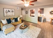 Thumbnail 13 of 56 - A living room with a couch, coffee table, and a ceiling fan.