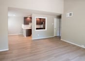 Thumbnail 29 of 56 - A spacious room with wooden flooring and a kitchen area in the background.