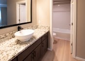 Thumbnail 34 of 56 - A bathroom with a marble countertop and a white sink.