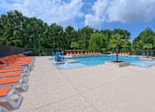 Thumbnail 42 of 48 - A pool surrounded by orange chairs and trees.