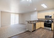 Thumbnail 33 of 61 - A spacious kitchen with wooden floors and a stainless steel oven.