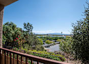 Thumbnail 51 of 61 - A view from a balcony overlooking a parking lot and trees.