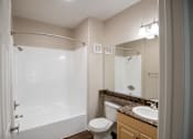 Thumbnail 40 of 61 - A white toilet sits next to a sink in a bathroom.