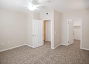 Thumbnail 47 of 61 - A room with a carpeted floor and a ceiling fan.