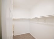 Thumbnail 41 of 61 - A white closet with a carpeted floor and a door on the left.