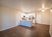 Thumbnail 54 of 61 - A kitchen with white cabinets and appliances is in the middle of a room with wood floors.
