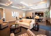 Thumbnail 15 of 61 - A well-lit living room with a white sofa, a coffee table, and a dining table.