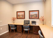 Thumbnail 17 of 61 - A room with a desk, chairs, and two framed pictures on the wall.