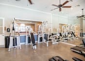Thumbnail 20 of 61 - A gym with a variety of equipment including weights and cardio machines.