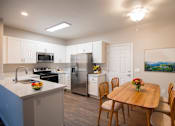Thumbnail 25 of 61 - A kitchen with a table and chairs.