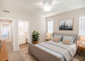 Thumbnail 24 of 61 - A bedroom with a large bed and a ceiling fan.