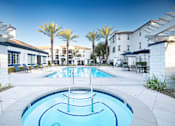 Thumbnail 3 of 61 - A swimming pool in a resort with palm trees.
