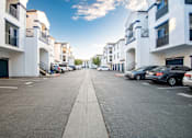 Thumbnail 45 of 61 - A street view of a residential area with cars parked on the side.