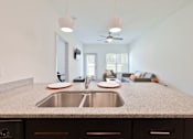 Thumbnail 61 of 66 - A kitchen with a granite countertop and a stainless steel sink.