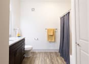 Thumbnail 60 of 66 - A bathroom with a toilet, sink, and shower curtain.