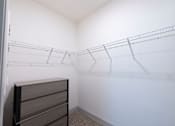 Thumbnail 57 of 66 - A white closet with a wire shelving unit and a brown dresser.