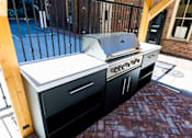 Thumbnail 6 of 81 - A black and white outdoor kitchen with a grill and sink.