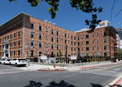Thumbnail 1 of 81 - A large brick building with a black fence in front of it.
