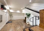 Thumbnail 13 of 81 - A room with a wooden floor and a staircase with a black railing.