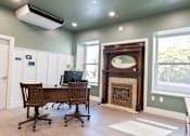Thumbnail 14 of 81 - A room with a fireplace and a desk with chairs.