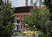 Thumbnail 4 of 81 - A building with a red brick facade is surrounded by trees.