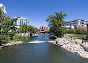 Thumbnail 21 of 81 - A river flows through a city with buildings on either side.