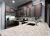 Thumbnail 28 of 81 - A kitchen with granite countertops and stainless steel appliances.