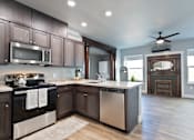 Thumbnail 29 of 81 - A modern kitchen with dark wood cabinets and stainless steel appliances.