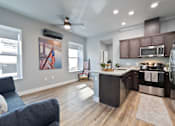 Thumbnail 39 of 81 - A modern kitchen with dark wood floors and stainless steel appliances.