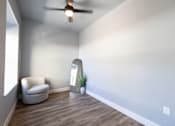 Thumbnail 44 of 81 - A room with a ceiling fan and a chair.