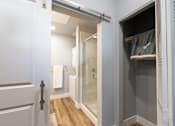 Thumbnail 48 of 81 - A white door is open to a bathroom with a walk-in shower.