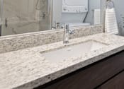 Thumbnail 50 of 81 - A bathroom with a sink, mirror, and shower.