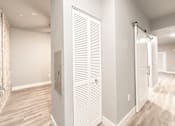 Thumbnail 53 of 81 - A white closet with a sliding door and a mirror on the wall.