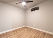 Thumbnail 54 of 81 - A room with a ceiling fan and an air conditioner unit on the wall.
