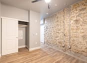 Thumbnail 55 of 81 - A room with a stone wall and a ceiling fan.