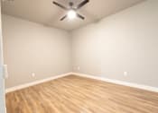 Thumbnail 60 of 81 - A room with a ceiling fan and wooden flooring.