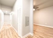 Thumbnail 62 of 81 - A long hallway with wood floors and white walls.