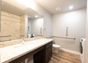 Thumbnail 71 of 81 - A bathroom with a marble countertop and a toilet.