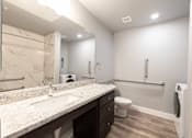 Thumbnail 72 of 81 - A bathroom with a marble countertop and a toilet.