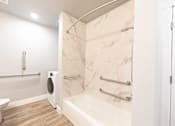 Thumbnail 73 of 81 - A white bathroom with a marble shower and toilet.
