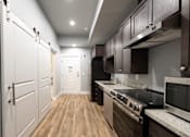 Thumbnail 77 of 81 - A modern kitchen with dark wood cabinets and stainless steel appliances.