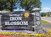 Thumbnail 1 of 24 - A sign for The Village at Iron Blossom Apartment Homes is shown.