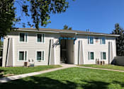 Thumbnail 2 of 24 - A white house with a blue awning and a green lawn in front.