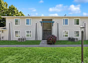 Thumbnail 4 of 24 - A small building with a blue awning and a red bush in front.