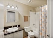 Thumbnail 7 of 24 - A bathroom with a sink, toilet, and shower.