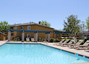 Thumbnail 21 of 24 - A swimming pool in front of a building with sun loungers.