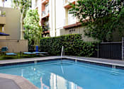 Thumbnail 9 of 11 - View of gated community pool with lounge chairs and seating