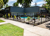 Thumbnail 14 of 24 - View of gated community pool area with lounge chairs and seating