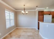 Thumbnail 13 of 54 - View of dining room with chandelier, peak into kitchen with brown cabinets, and white appliances